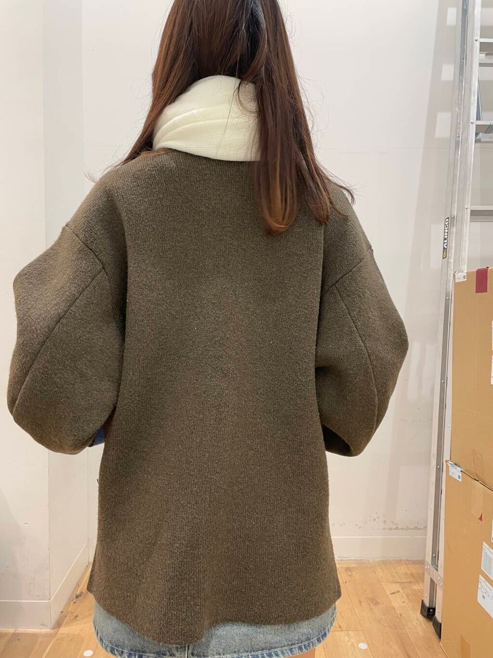 ブルー系のスカート、ブラウン系のその他アウター、ホワイト系のマフラーを着用したレディースの秋コーディネートの5枚目の写真