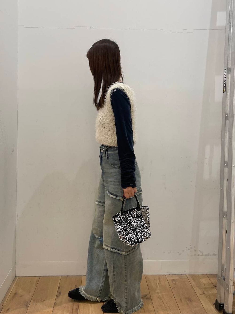 シルバー系のショルダーバッグ、ブルー系のTシャツ/カットソー、ブルー系のデニムパンツを着用したレディースの冬コーディネートの2枚目の写真