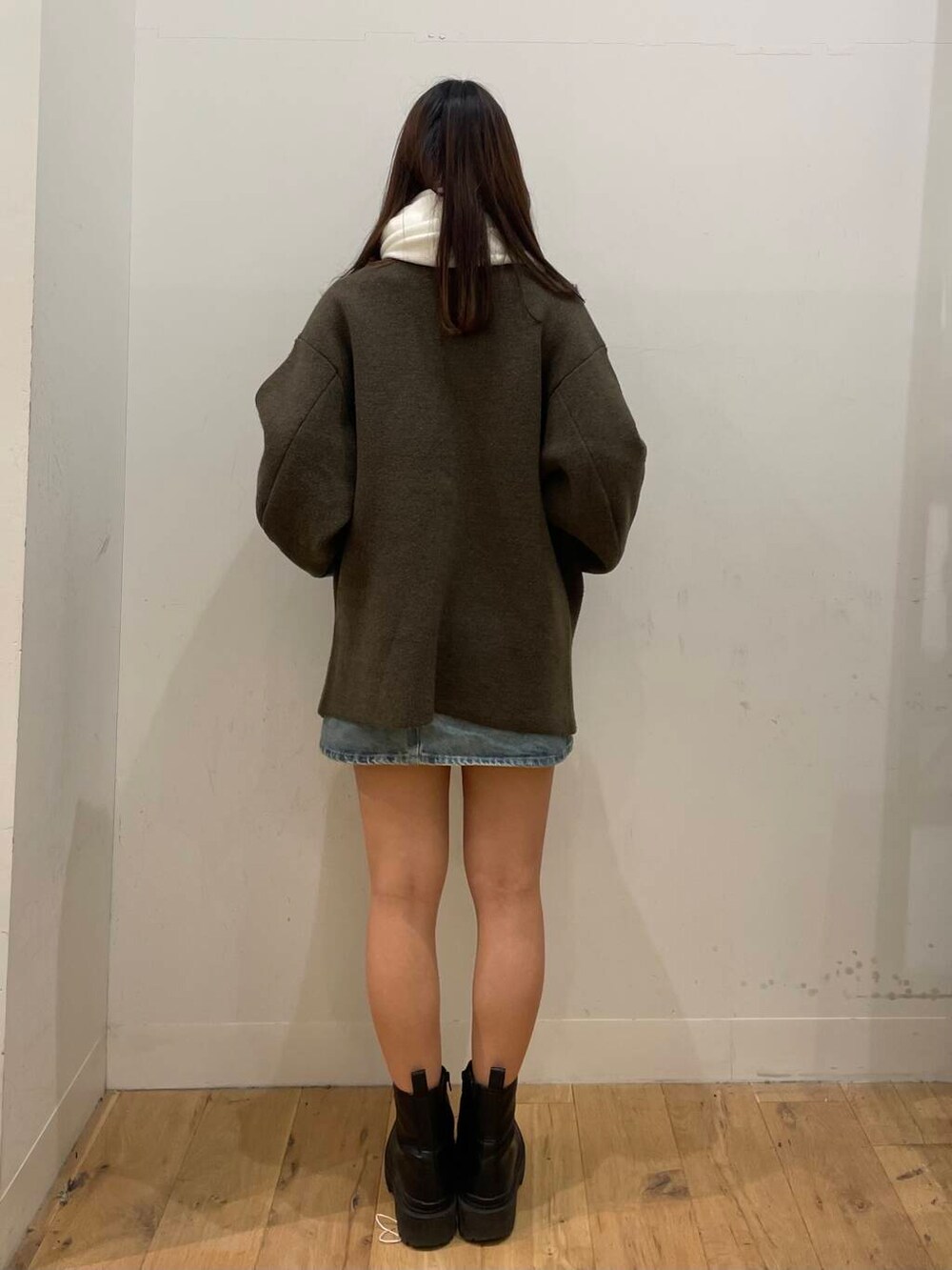 ブルー系のスカート、ブラウン系のその他アウター、ホワイト系のマフラーを着用したレディースの秋コーディネートの3枚目の写真