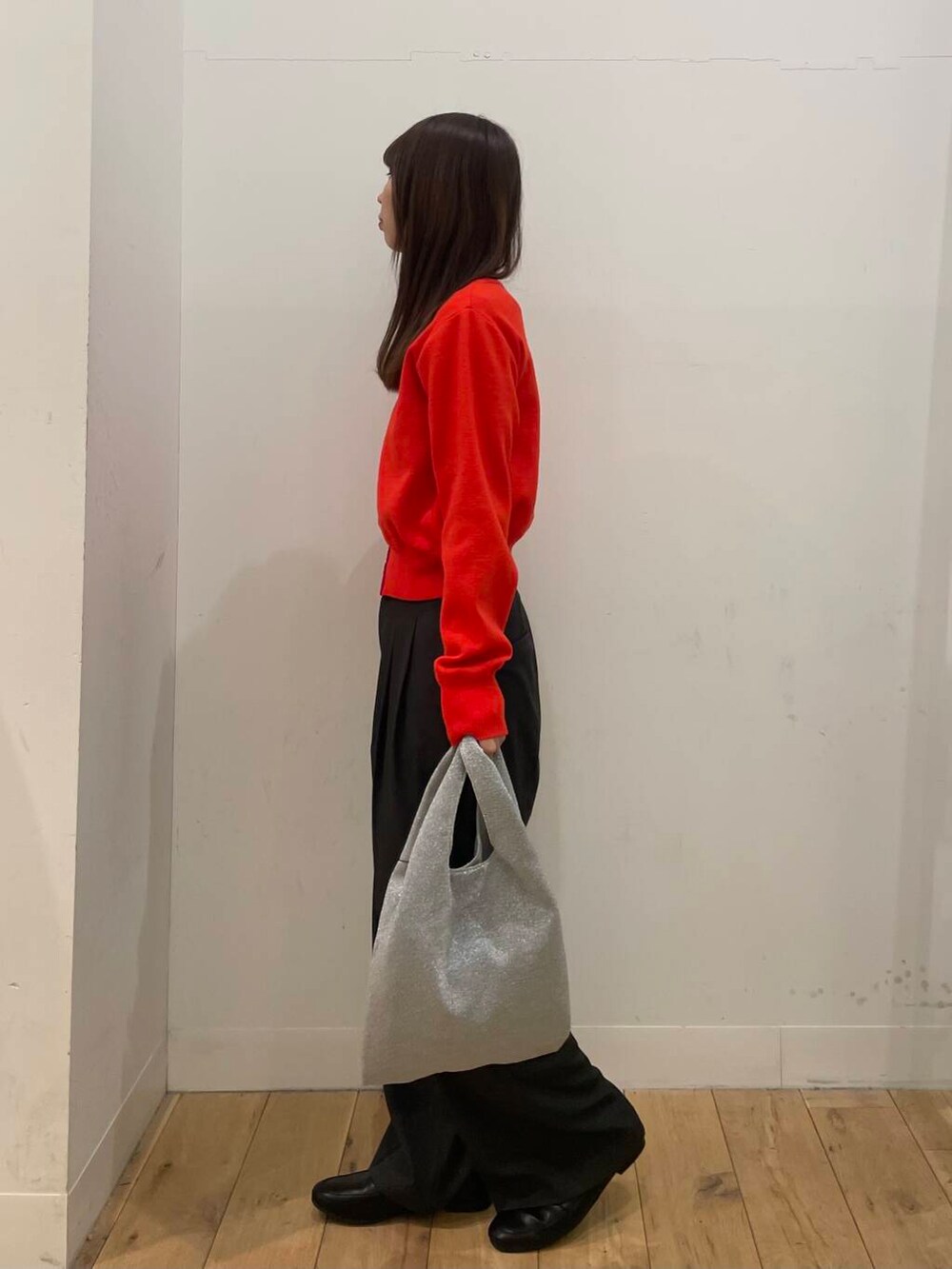 シルバー系のトートバッグ、レッド系のカーディガン/ボレロ、グレー系のその他パンツを着用したレディースの冬コーディネートの2枚目の写真