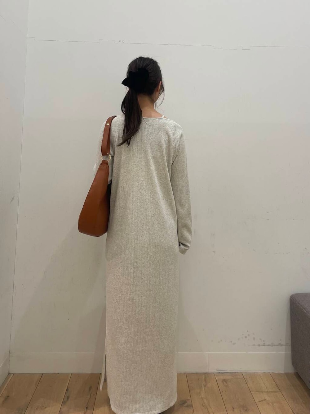 ブラウン系のショルダーバッグ、ブラック系のパンプス、ベージュ系のワンピースを着用したレディースの冬コーディネートの3枚目の写真