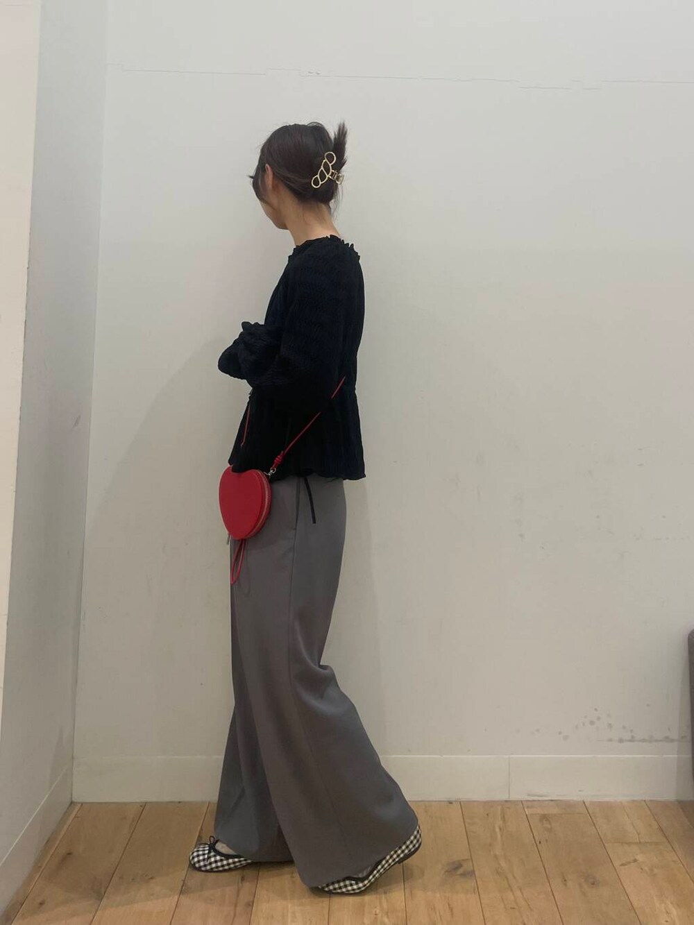 レッド系のショルダーバッグ、ブラック系のシャツ/ブラウス、グレー系のその他パンツを着用したレディースの春コーディネートの2枚目の写真