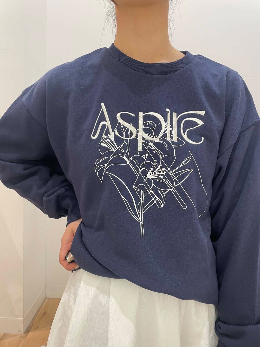 オレンジ系のハンドバッグ、ホワイト系のスカート、ブラック系のパンプスを着用したレディースの冬コーディネートの4枚目の写真