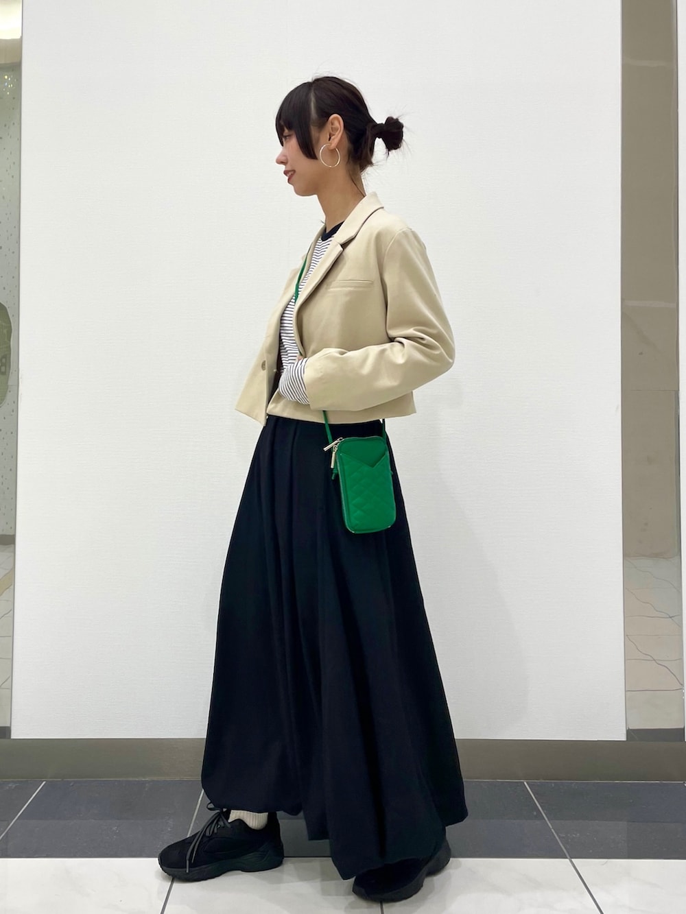 ベージュ系のその他アウター、ホワイト系のTシャツ/カットソー、ブラック系のスカートを着用したレディースの春コーディネートの2枚目の写真
