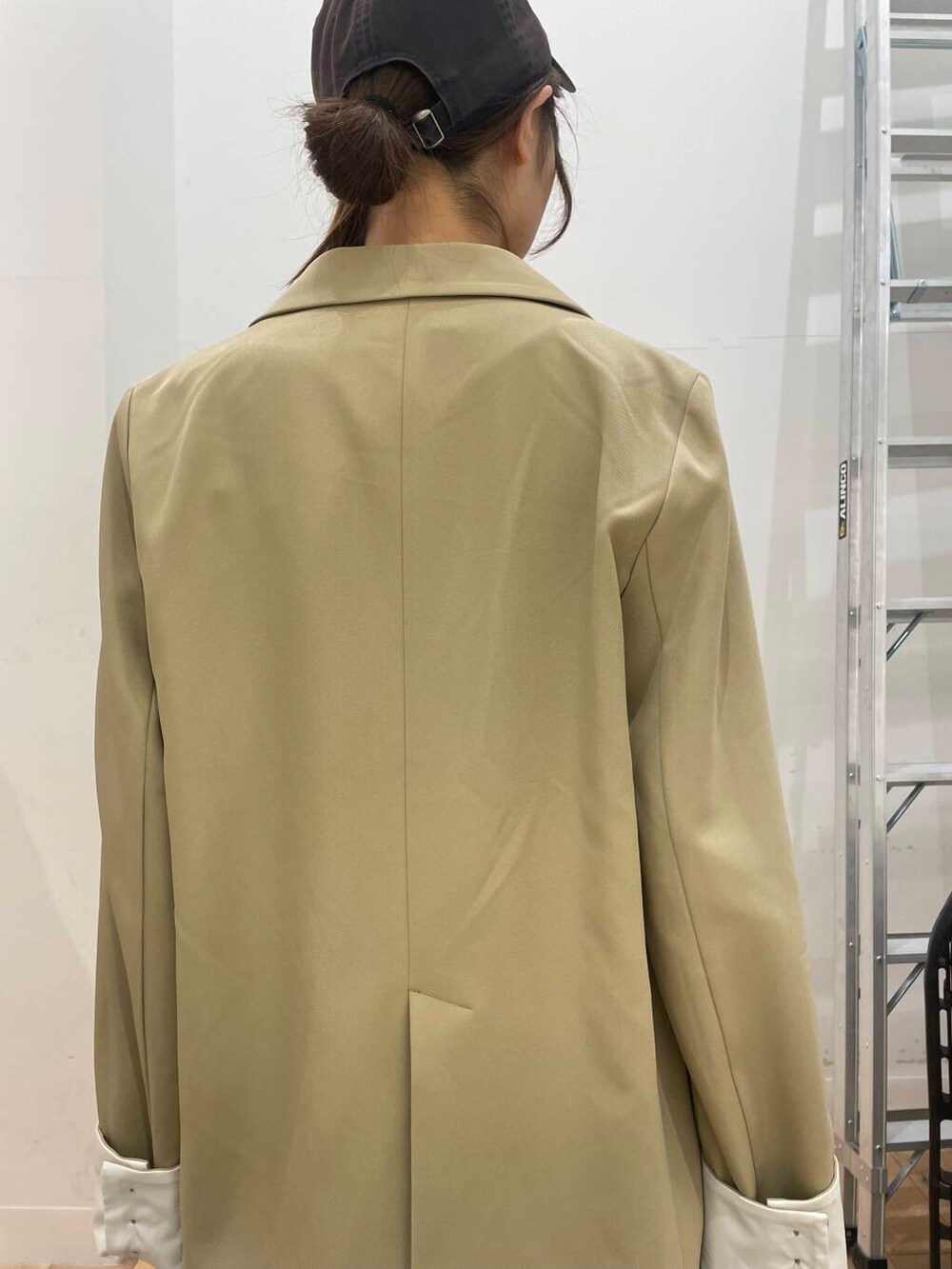 ベージュ系のパンプス、ブラック系のデニムパンツ、ベージュ系のテーラードジャケットを着用したレディースの冬コーディネートの5枚目の写真