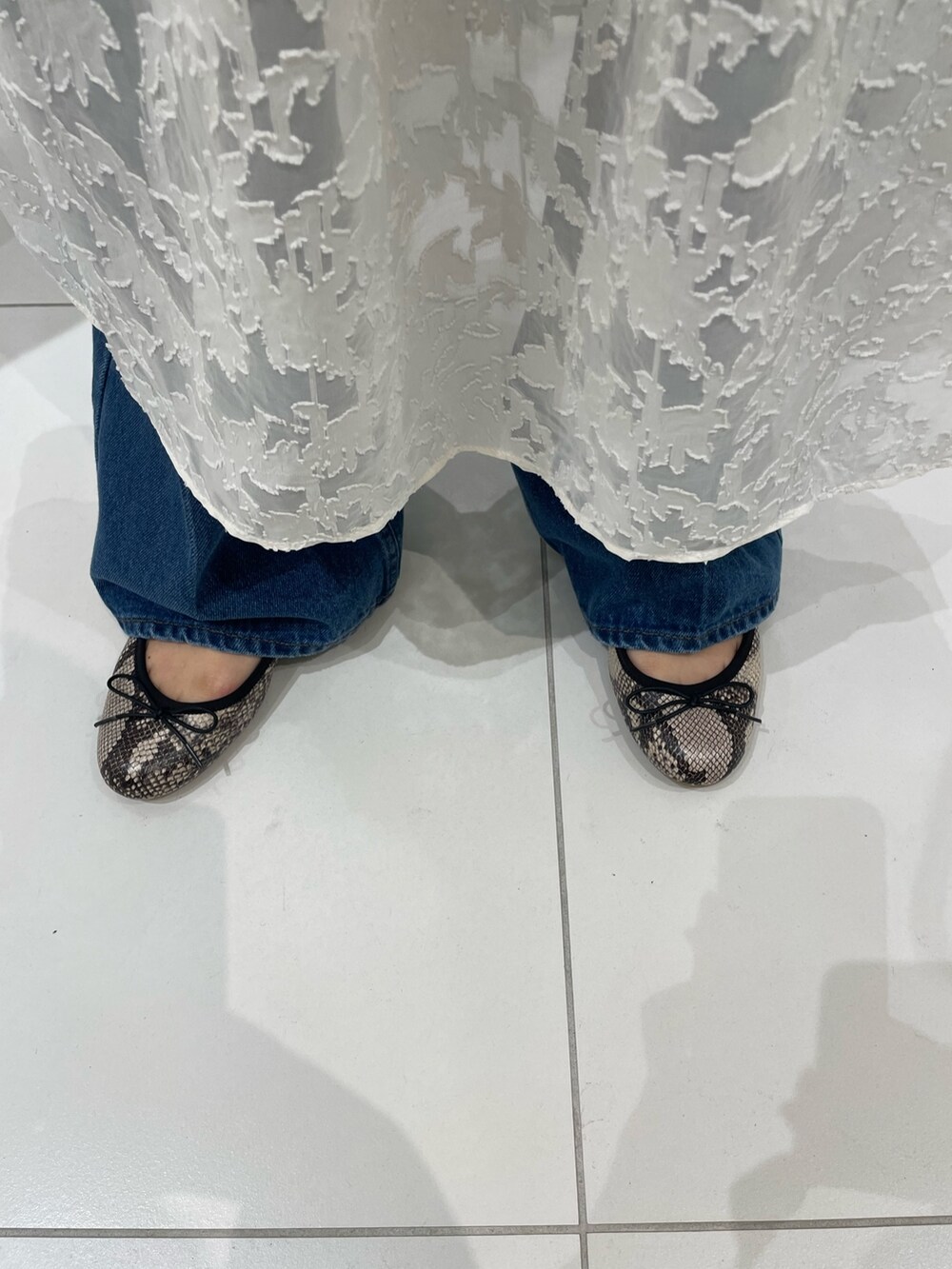 ホワイト系のワンピース、その他のバレエシューズ、ブルー系のデニムパンツを着用したレディースの春コーディネートの5枚目の写真