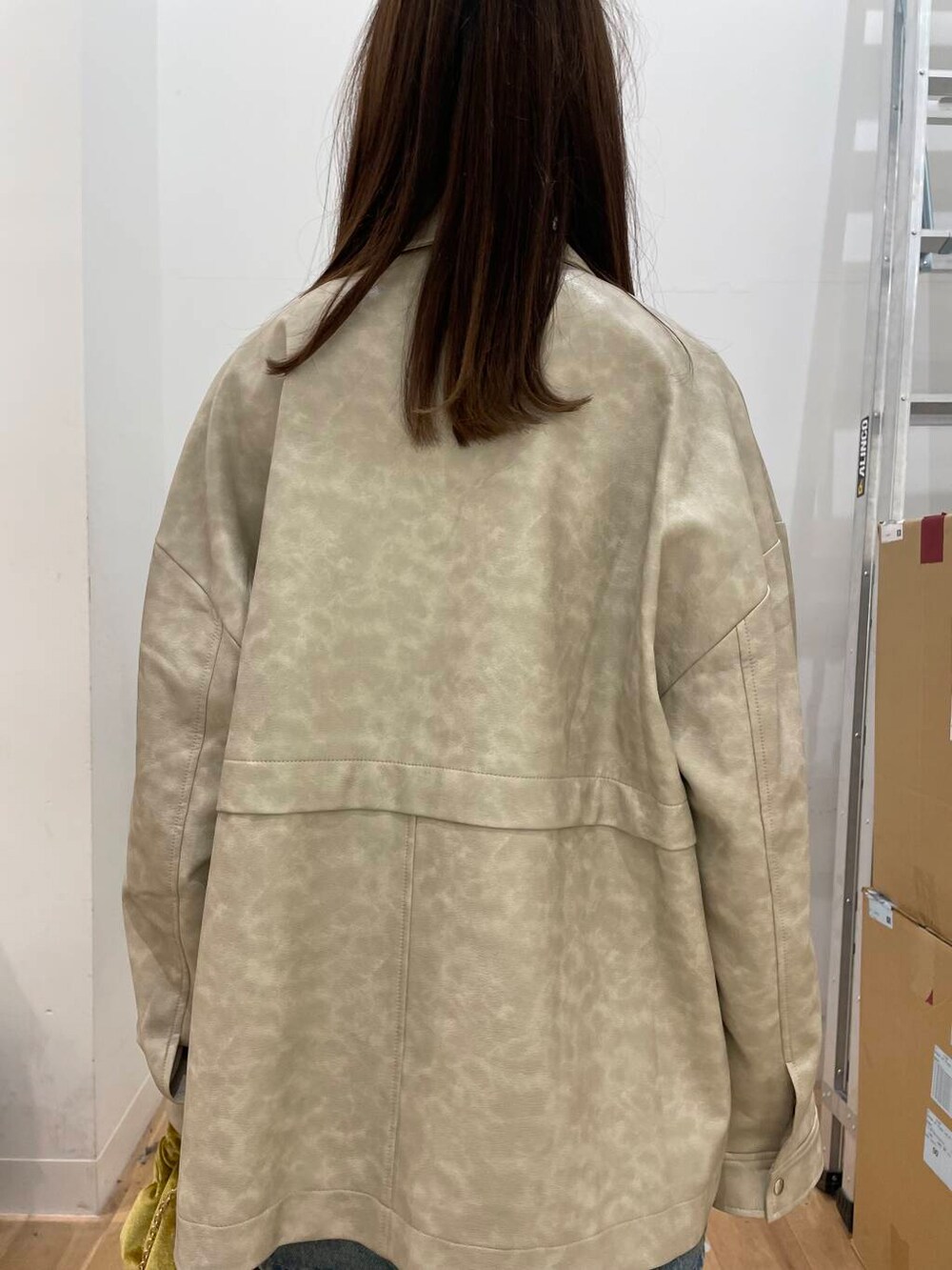 イエロー系のハンドバッグ、ブルー系のスカート、ホワイト系のその他アウターを着用したレディースの秋コーディネートの5枚目の写真