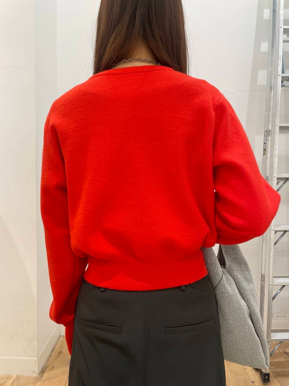 シルバー系のトートバッグ、レッド系のカーディガン/ボレロ、グレー系のその他パンツを着用したレディースの冬コーディネートの5枚目の写真