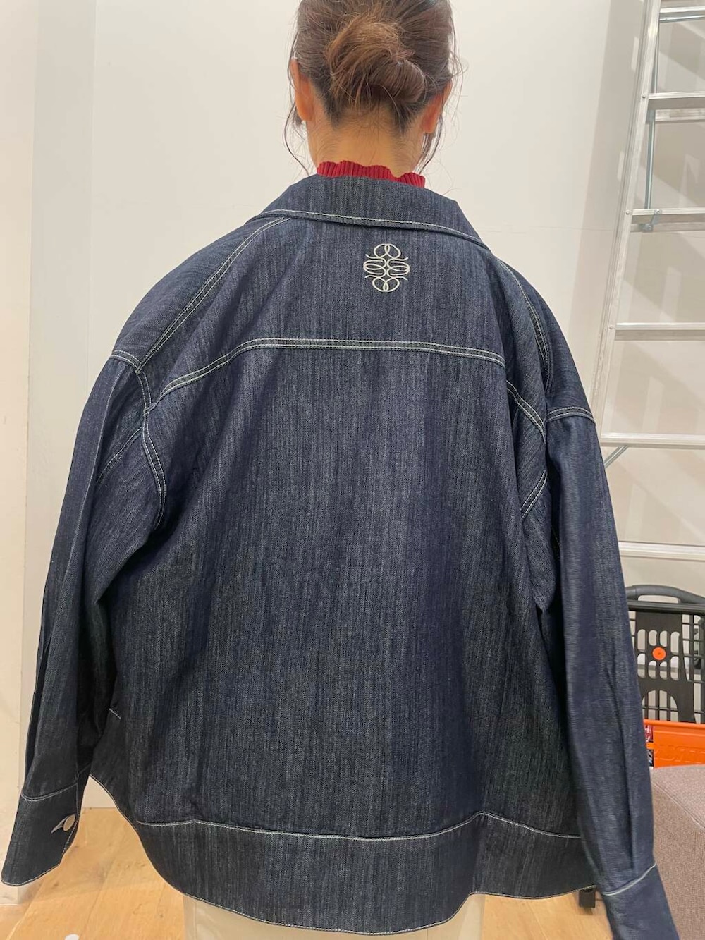 ブラック系のショルダーバッグ、レッド系のニット/セーター、ベージュ系のスカートを着用したレディースの秋コーディネートの5枚目の写真