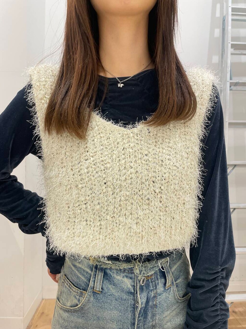 シルバー系のショルダーバッグ、ブルー系のTシャツ/カットソー、ブルー系のデニムパンツを着用したレディースの冬コーディネートの4枚目の写真