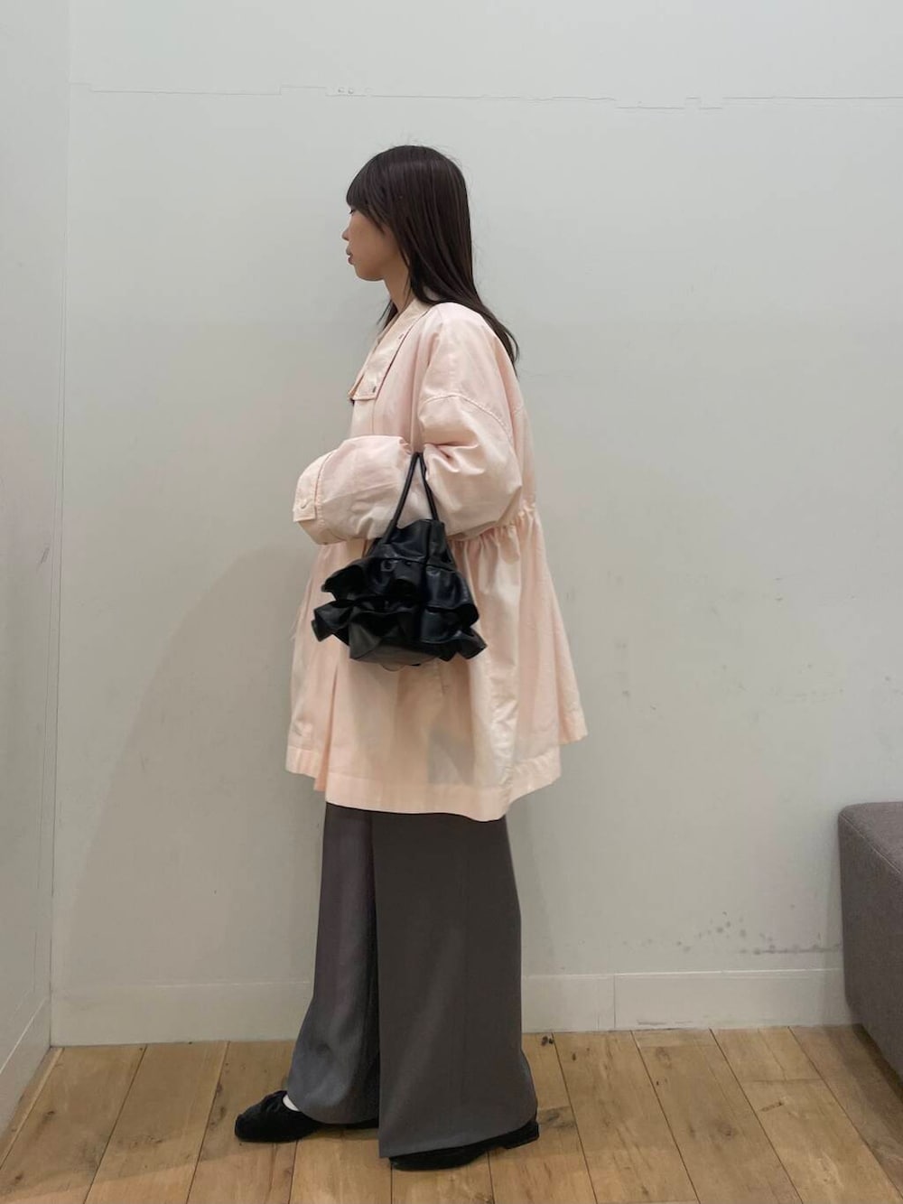 グレー系のその他パンツ、ピンク系のナイロンジャケット、ブラック系のハンドバッグを着用したレディースの冬コーディネートの2枚目の写真