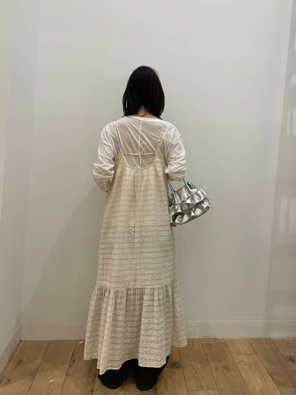 シルバー系のハンドバッグ、ホワイト系のTシャツ/カットソー、ホワイト系のワンピースを着用したレディースの春コーディネートの3枚目の写真