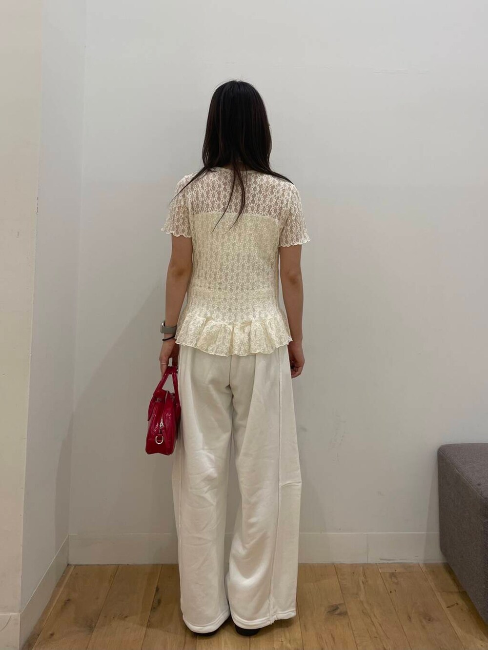 レッド系のボストンバッグ、ホワイト系のシャツ/ブラウスを着用したレディースの夏コーディネートの3枚目の写真