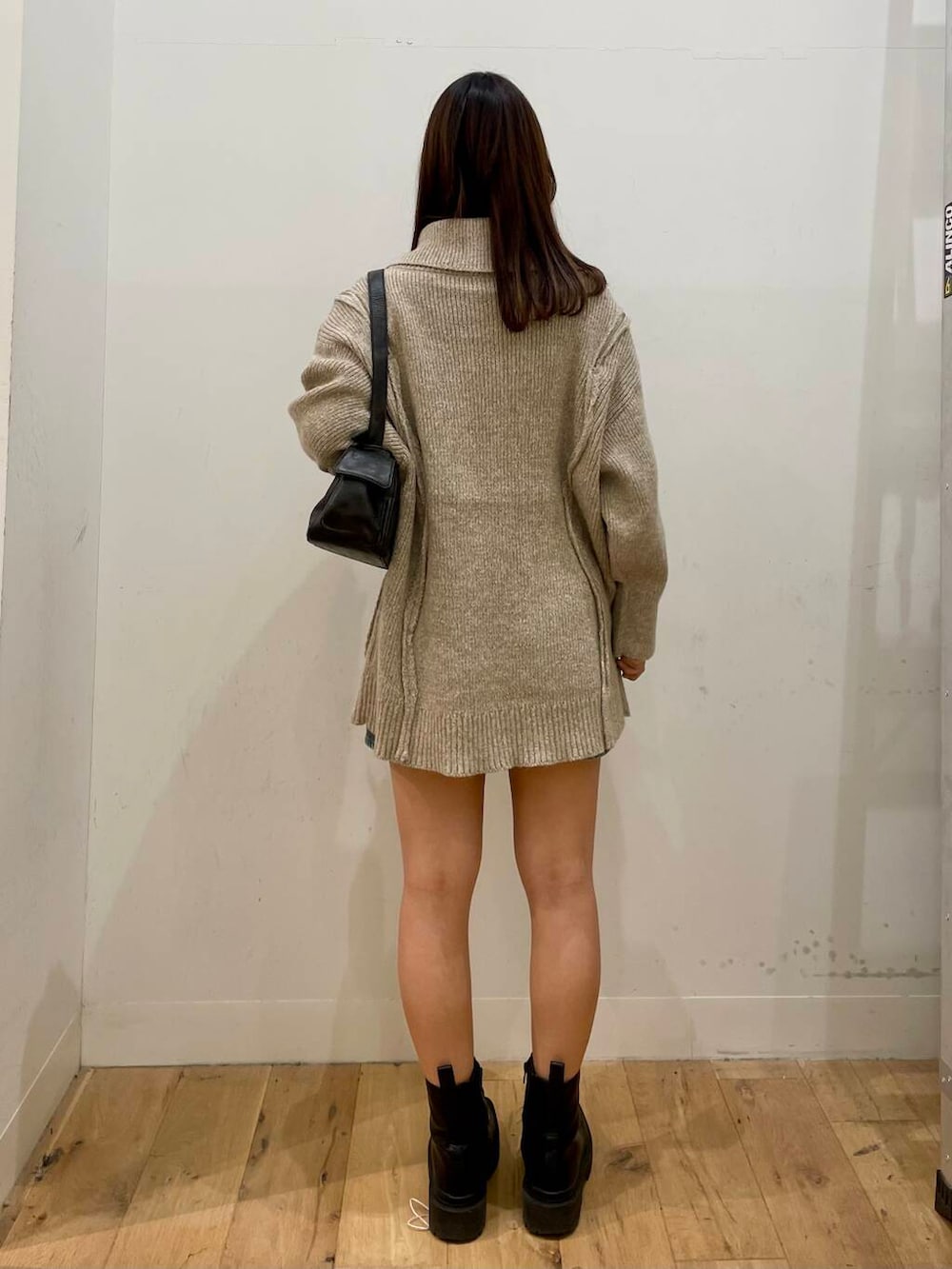 ベージュ系のニット/セーター、グレー系のハンドバッグ、ブルー系のスカートを着用したレディースの秋コーディネートの3枚目の写真