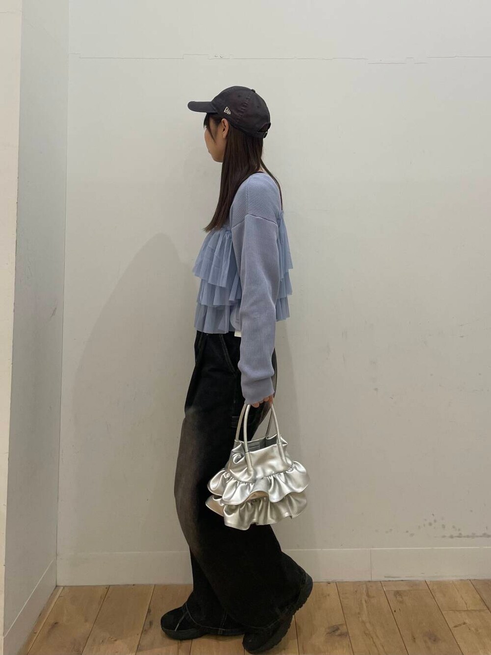 ブラック系のデニムパンツ、シルバー系のハンドバッグ、ブルー系のカーディガン/ボレロを着用したレディースの春コーディネートの2枚目の写真