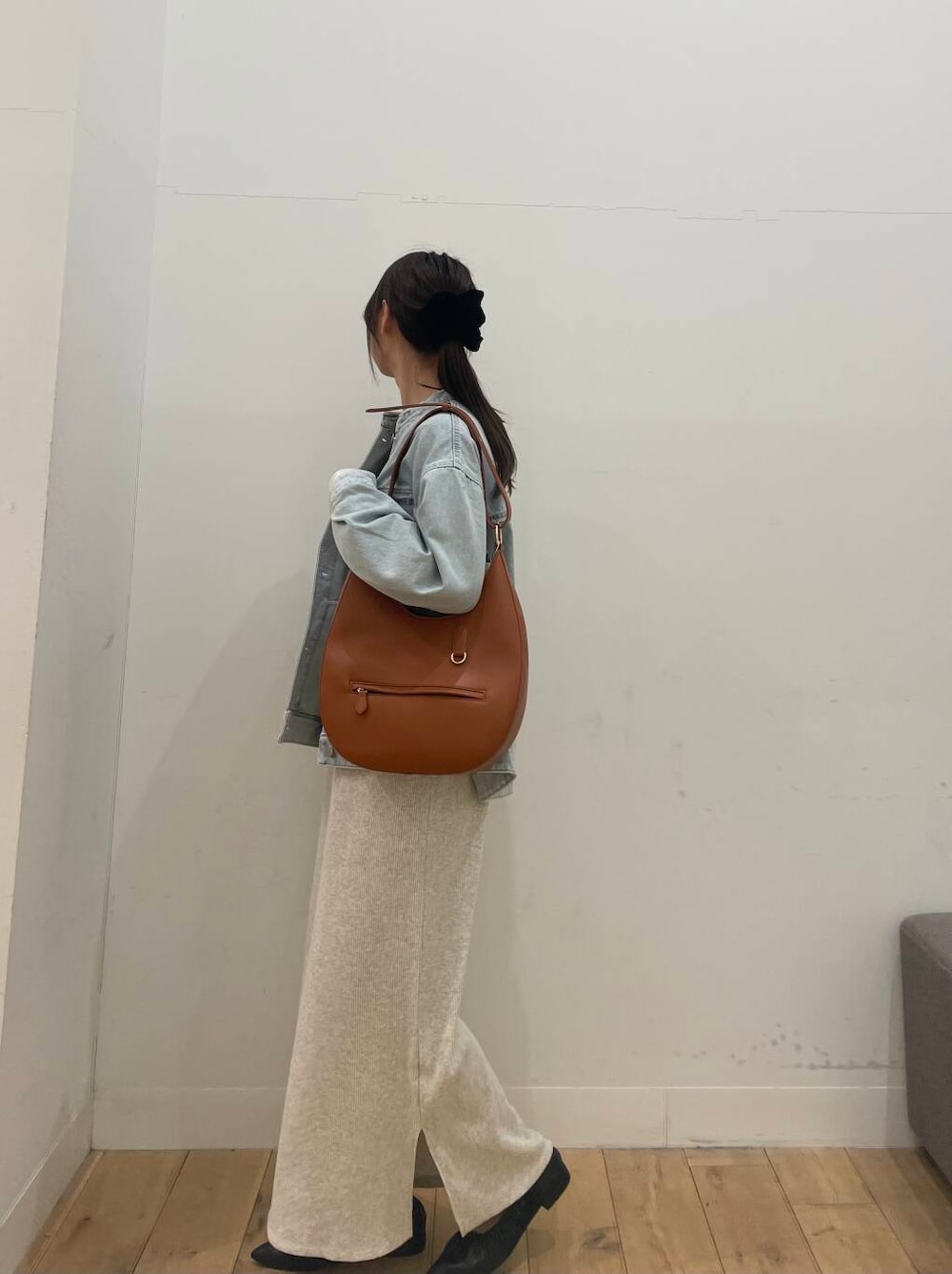 ブラウン系のショルダーバッグ、ブラック系のバレエシューズ、ベージュ系のワンピースを着用したレディースの冬コーディネートの2枚目の写真