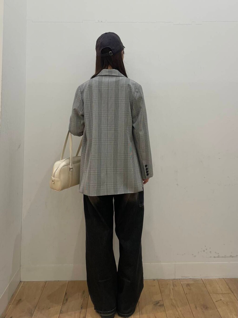 ブラック系のデニムパンツ、ホワイト系のボストンバッグ、ブルー系のTシャツ/カットソーを着用したレディースの春コーディネートの3枚目の写真