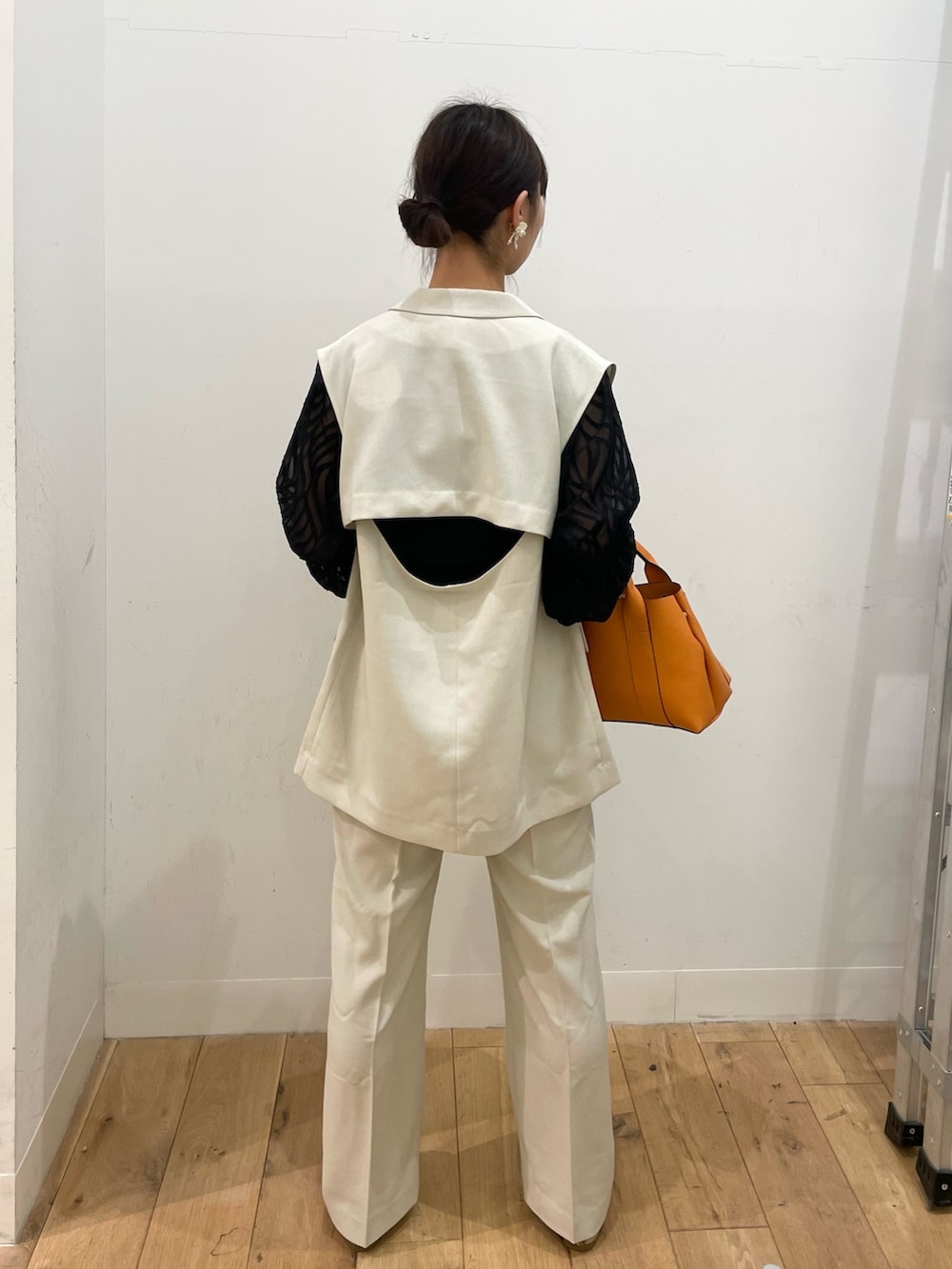 ベージュ系のその他アウター、ベージュ系のその他パンツ、オレンジ系のトートバッグを着用したレディースの春コーディネートの3枚目の写真