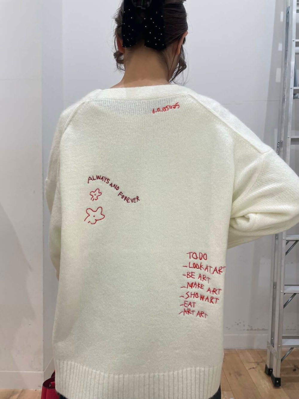 レッド系のトートバッグ、ホワイト系のTシャツ/カットソー、ホワイト系のカーディガン/ボレロを着用したレディースの冬コーディネートの5枚目の写真