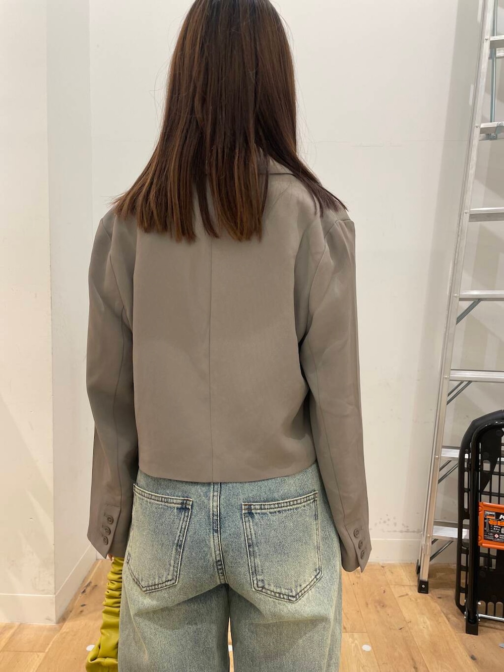 イエロー系のハンドバッグ、ブラック系のその他シューズ、ブルー系のデニムパンツを着用したレディースの秋コーディネートの5枚目の写真