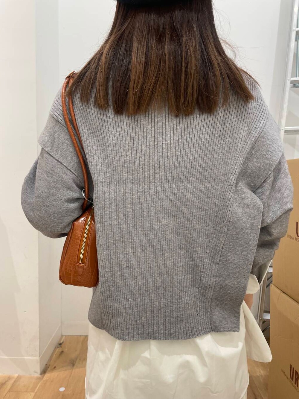 ホワイト系のシャツ/ブラウス、ブラック系のブーツ、オレンジ系のハンドバッグを着用したレディースの秋コーディネートの6枚目の写真