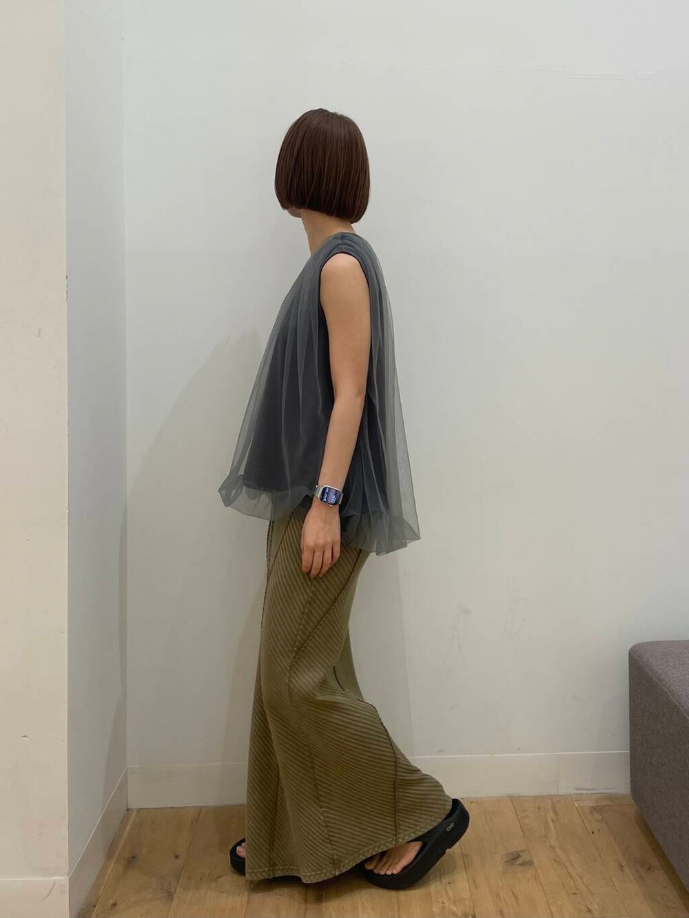 イエロー系のスカート、グレー系のTシャツ/カットソーを着用したレディースの夏コーディネートの2枚目の写真