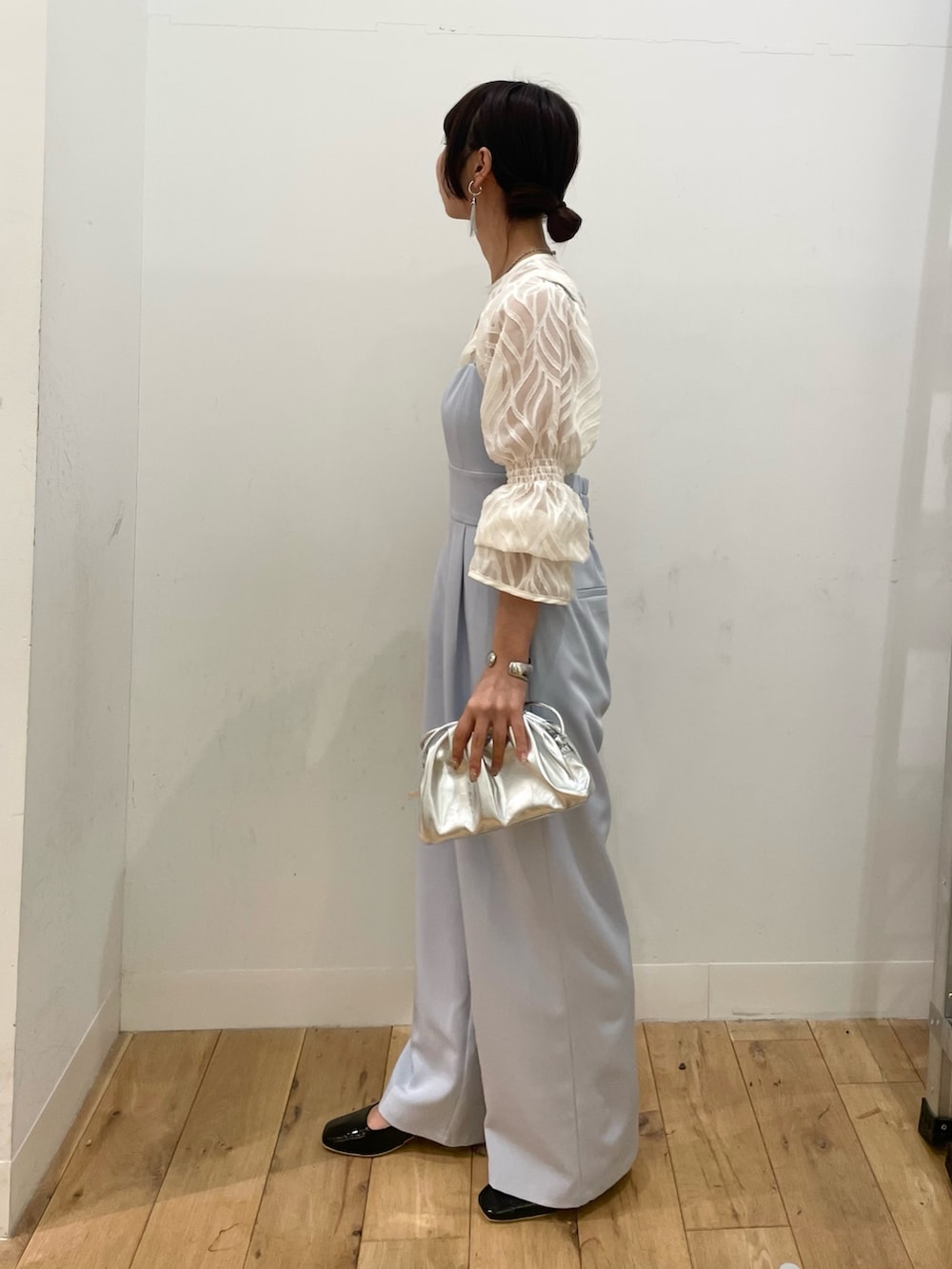 シルバー系のショルダーバッグ、ホワイト系のシャツ/ブラウス、ブルー系のサロペット/オーバーオールを着用したレディースの春コーディネートの2枚目の写真