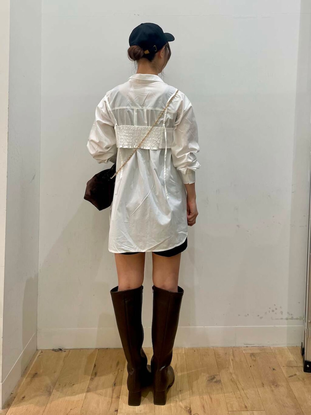 ブラウン系のハンドバッグ、ブラウン系のブーツ、ホワイト系のシャツ/ブラウスを着用したレディースの秋コーディネートの3枚目の写真