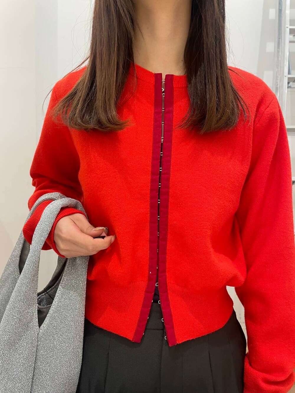 シルバー系のトートバッグ、レッド系のカーディガン/ボレロ、グレー系のその他パンツを着用したレディースの冬コーディネートの4枚目の写真