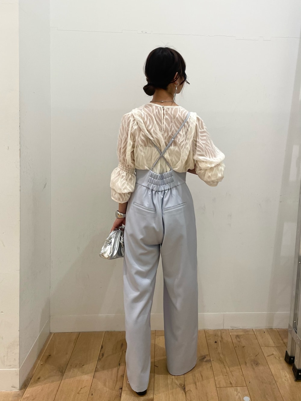 シルバー系のショルダーバッグ、ホワイト系のシャツ/ブラウス、ブルー系のサロペット/オーバーオールを着用したレディースの春コーディネートの3枚目の写真