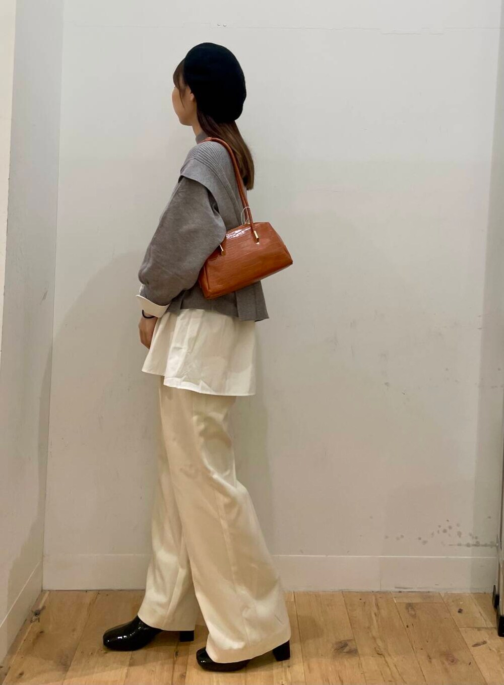 ホワイト系のシャツ/ブラウス、ブラック系のブーツ、オレンジ系のハンドバッグを着用したレディースの秋コーディネートの3枚目の写真