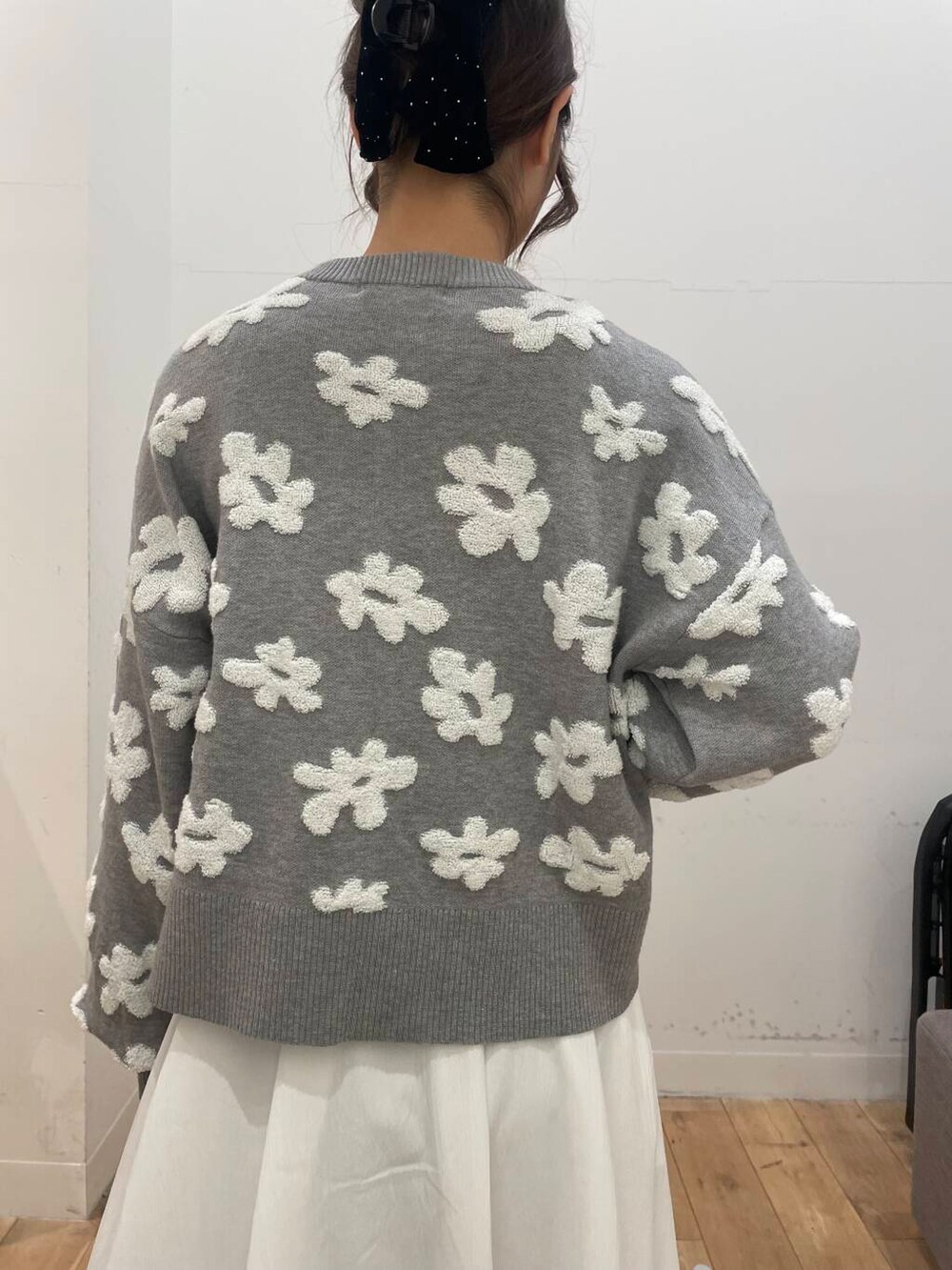 ホワイト系のスカート、ブラック系のパンプス、グレー系のカーディガン/ボレロを着用したレディースの冬コーディネートの5枚目の写真