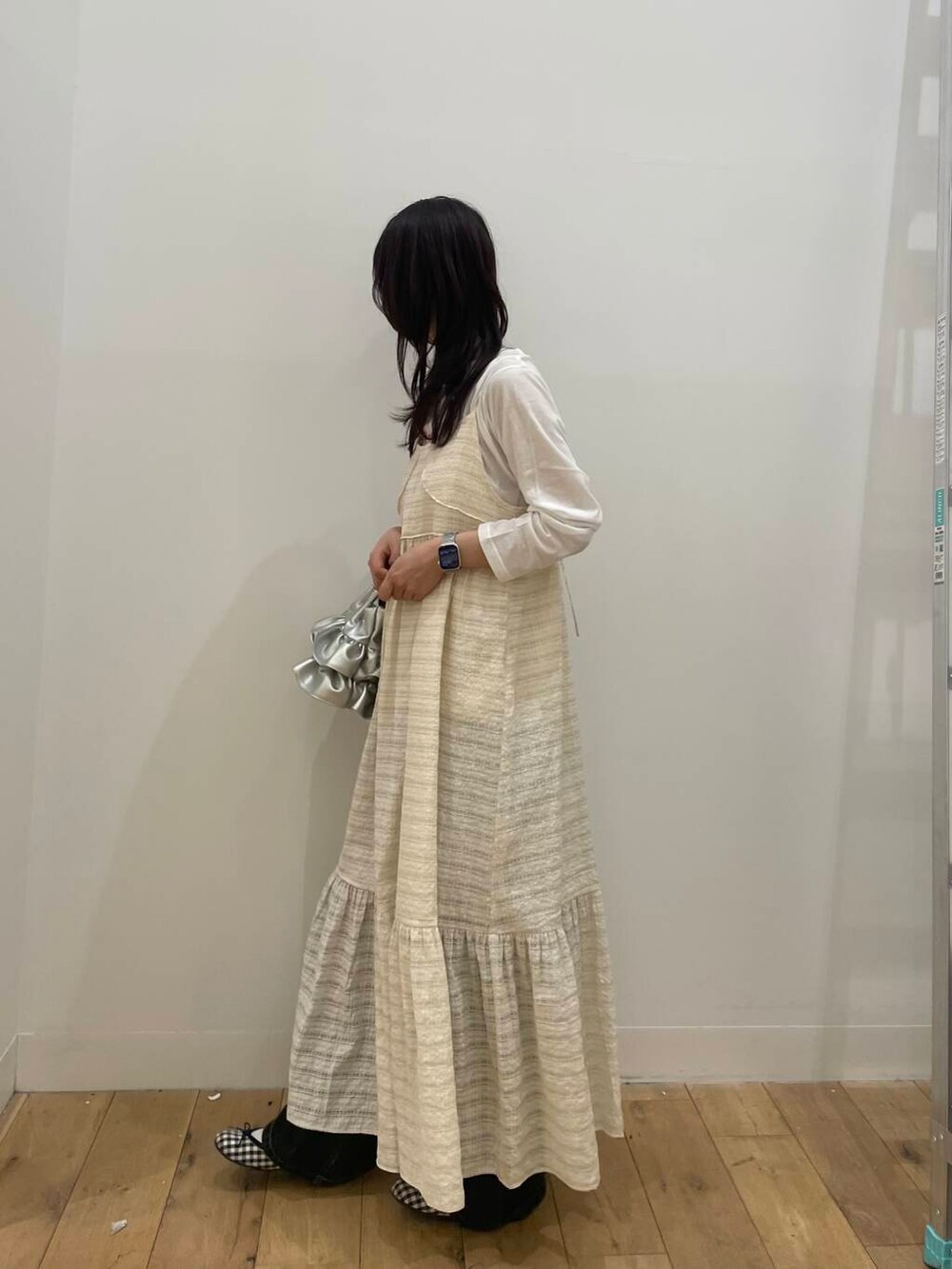 シルバー系のハンドバッグ、ホワイト系のTシャツ/カットソー、ホワイト系のワンピースを着用したレディースの春コーディネートの2枚目の写真