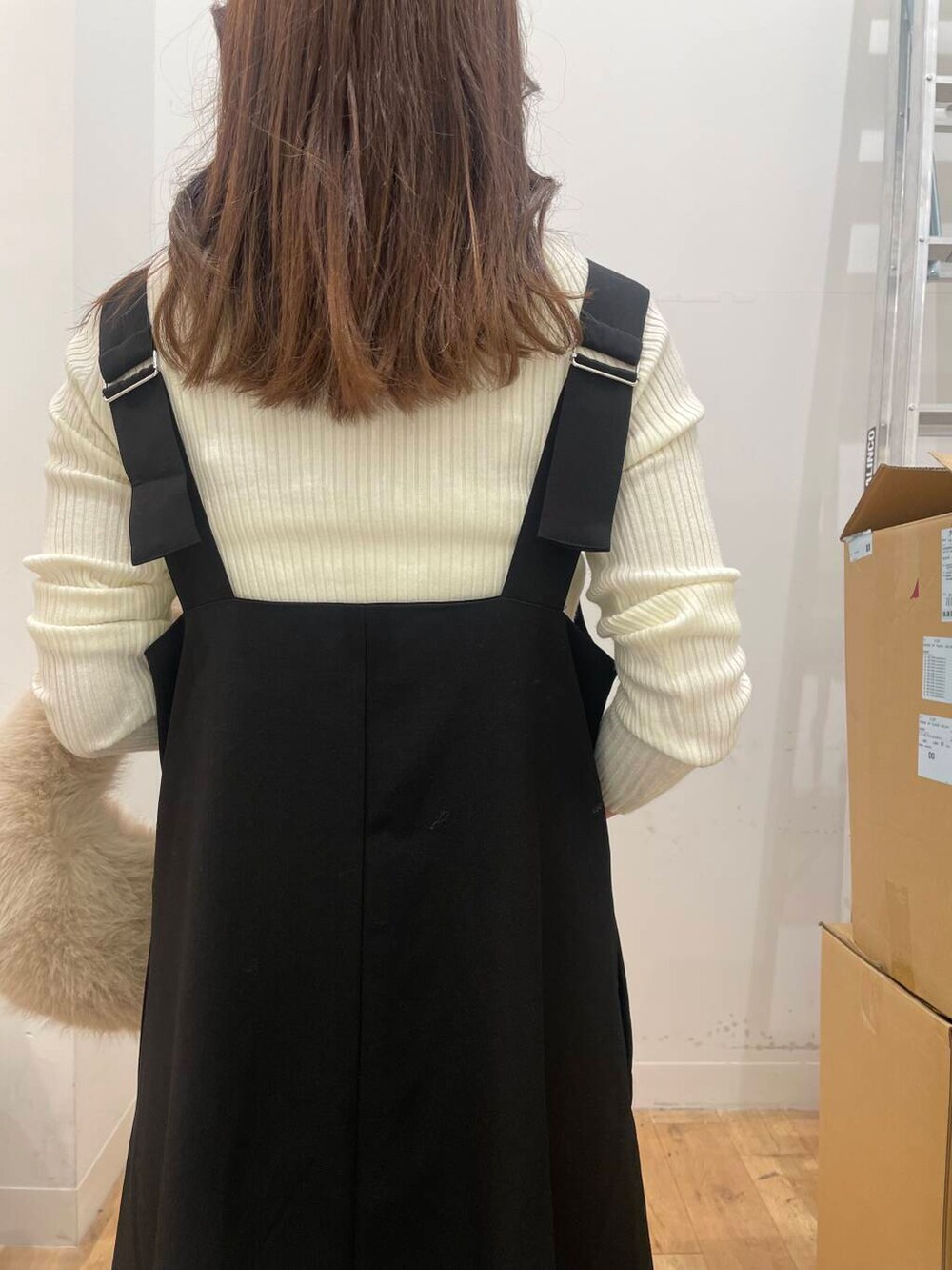 ホワイト系のニット/セーター、ベージュ系のハンドバッグ、ブラック系のワンピースを着用したレディースの秋コーディネートの5枚目の写真