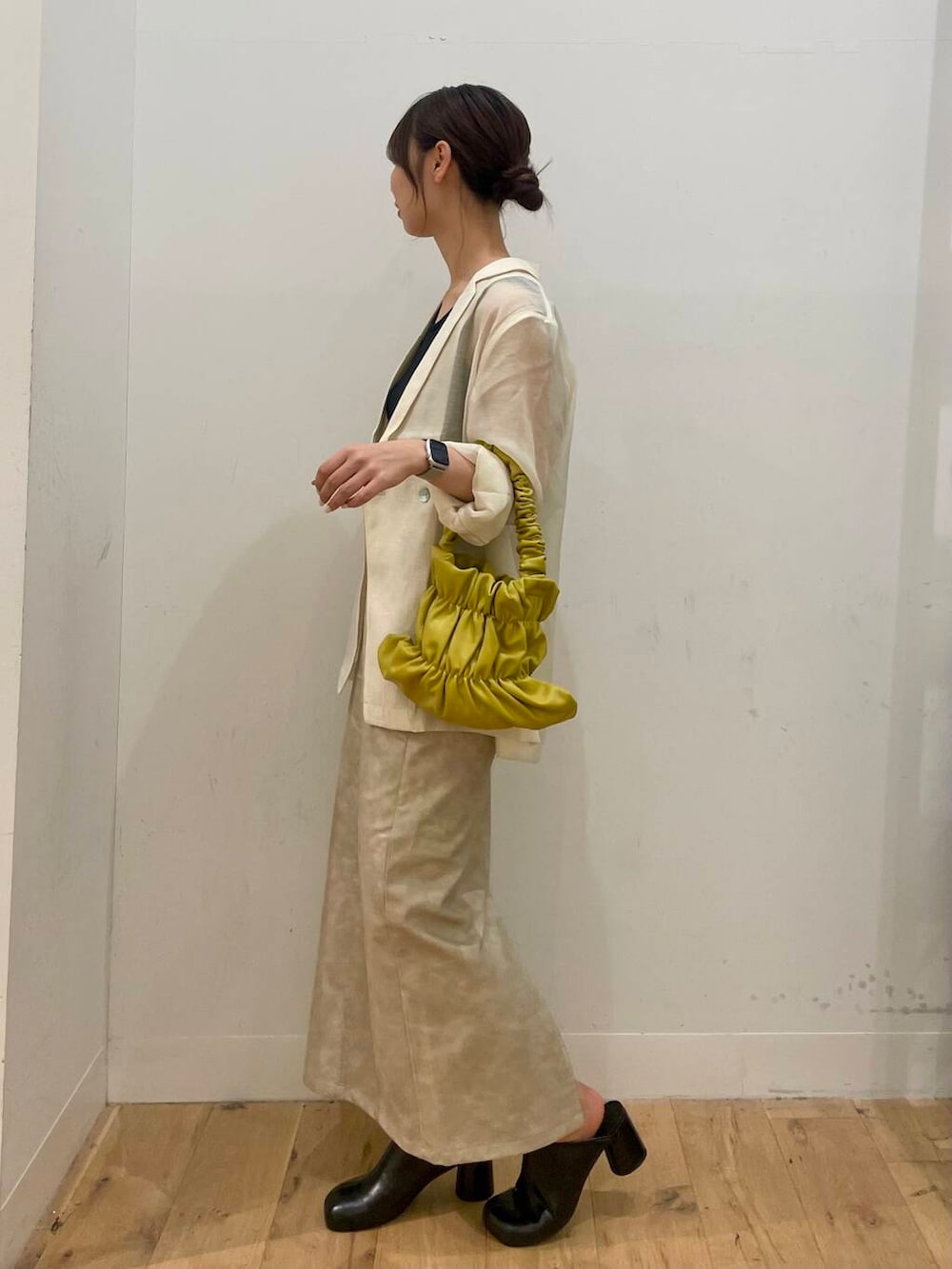 イエロー系のハンドバッグ、ブラック系のTシャツ/カットソー、ブラック系のサンダルを着用したレディースの秋コーディネートの2枚目の写真