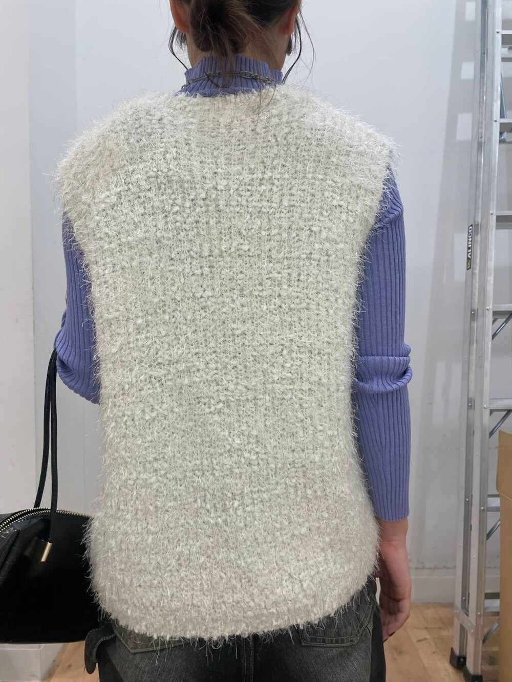 パープル系のニット/セーター、ブラック系のサンダル、ホワイト系のベストを着用したレディースの秋コーディネートの5枚目の写真