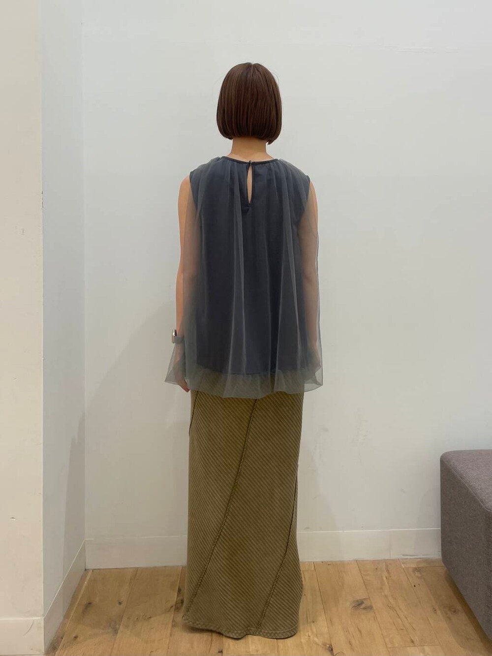 イエロー系のスカート、グレー系のTシャツ/カットソーを着用したレディースの夏コーディネートの3枚目の写真