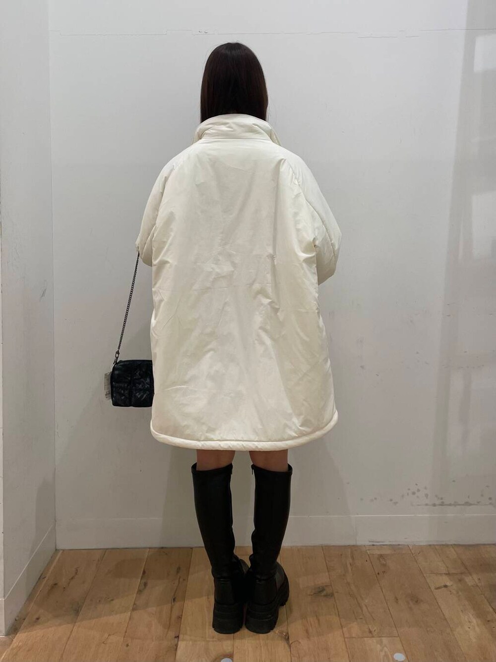 ブルー系のスカート、グレー系のTシャツ/カットソー、ホワイト系のダウンジャケット/コートを着用したレディースの秋コーディネートの3枚目の写真