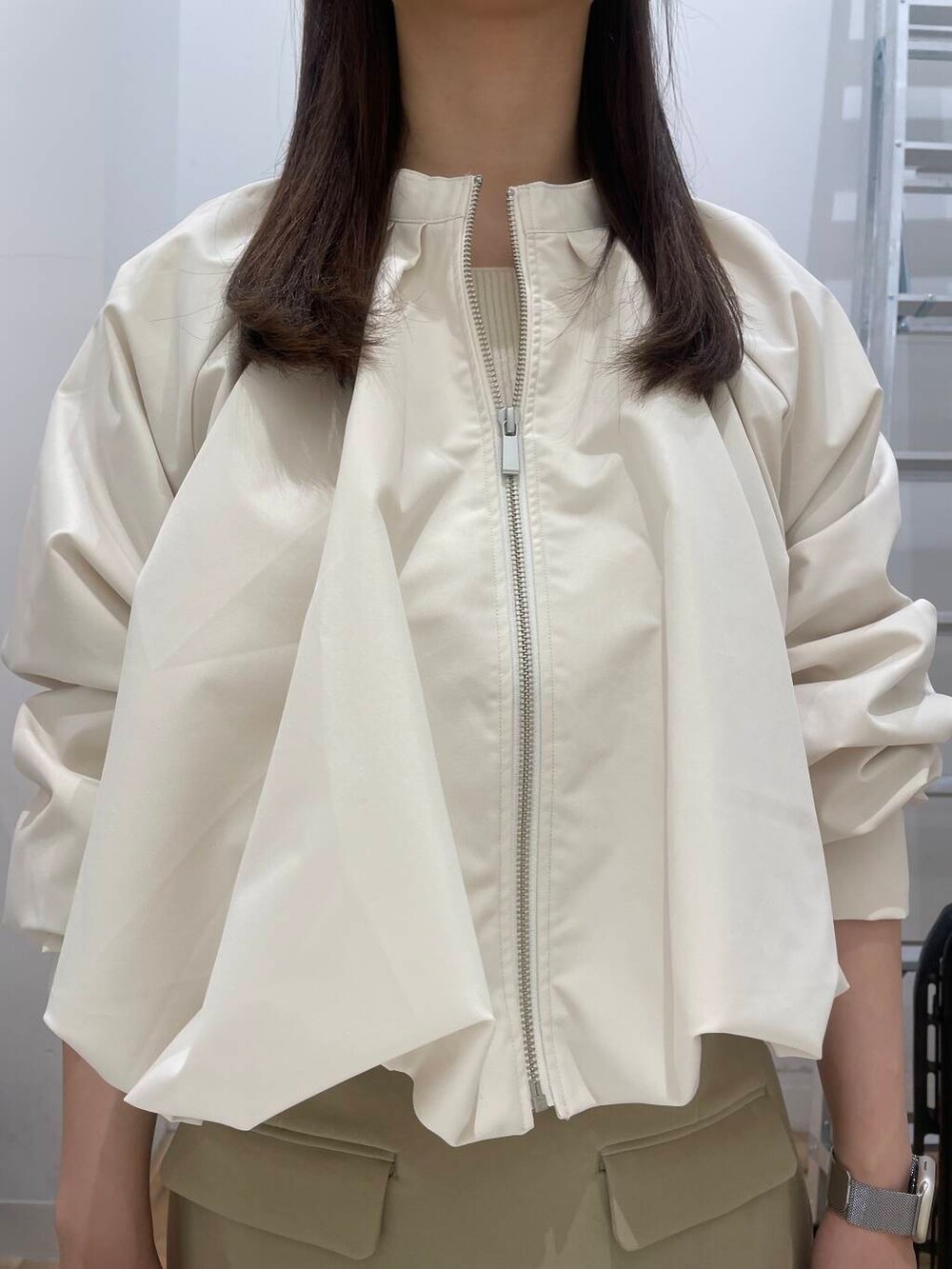 ブラック系のブーツ、ブラック系のボストンバッグ、ベージュ系のスカートを着用したレディースの冬コーディネートの4枚目の写真