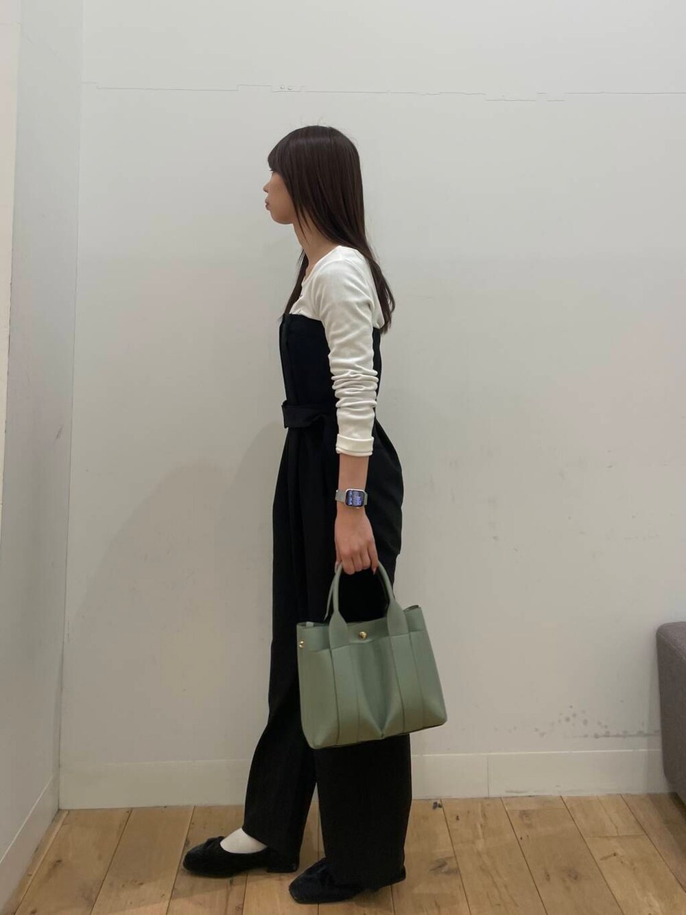 ブラック系のサロペット/オーバーオール、グリーン系のトートバッグを着用したレディースの冬コーディネートの2枚目の写真