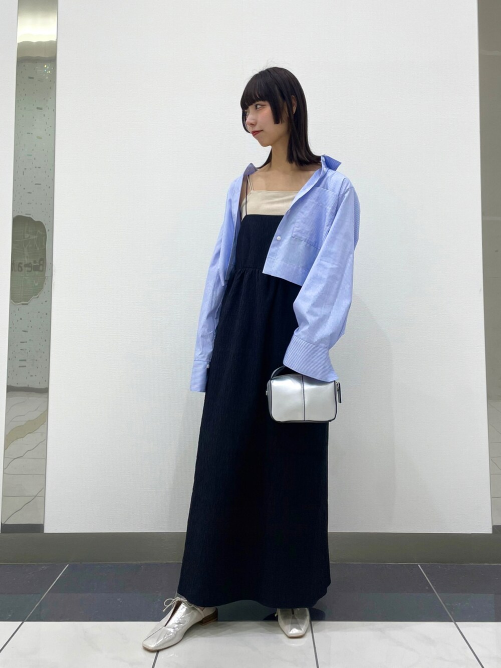 シルバー系のその他シューズ、ブルー系のシャツ/ブラウス、ブラック系のワンピースを着用したレディースの春コーディネートの2枚目の写真
