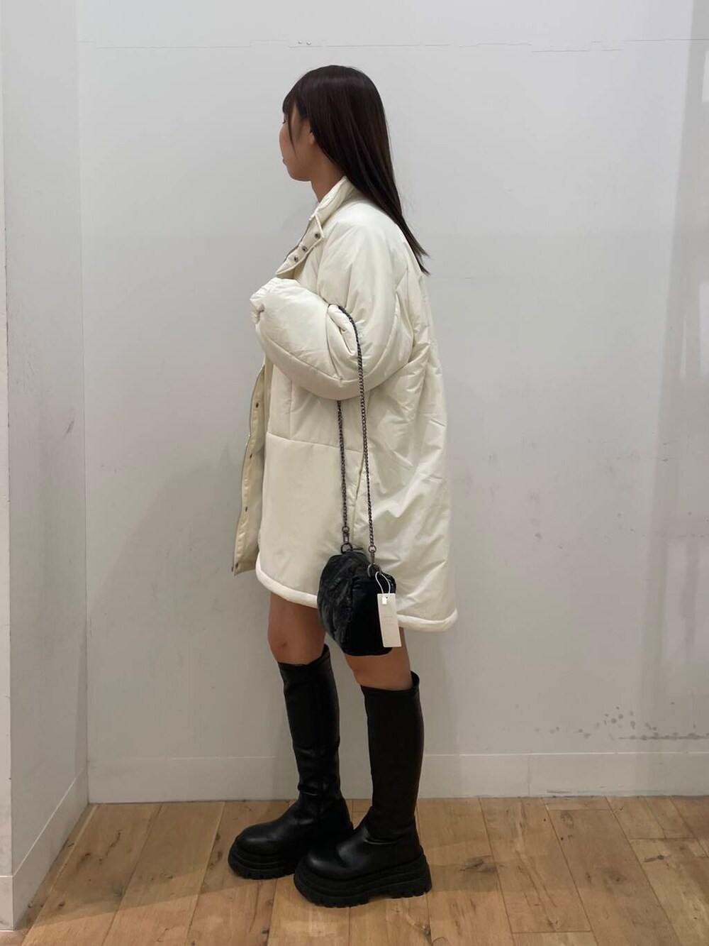 ブルー系のスカート、グレー系のTシャツ/カットソー、ホワイト系のダウンジャケット/コートを着用したレディースの秋コーディネートの2枚目の写真