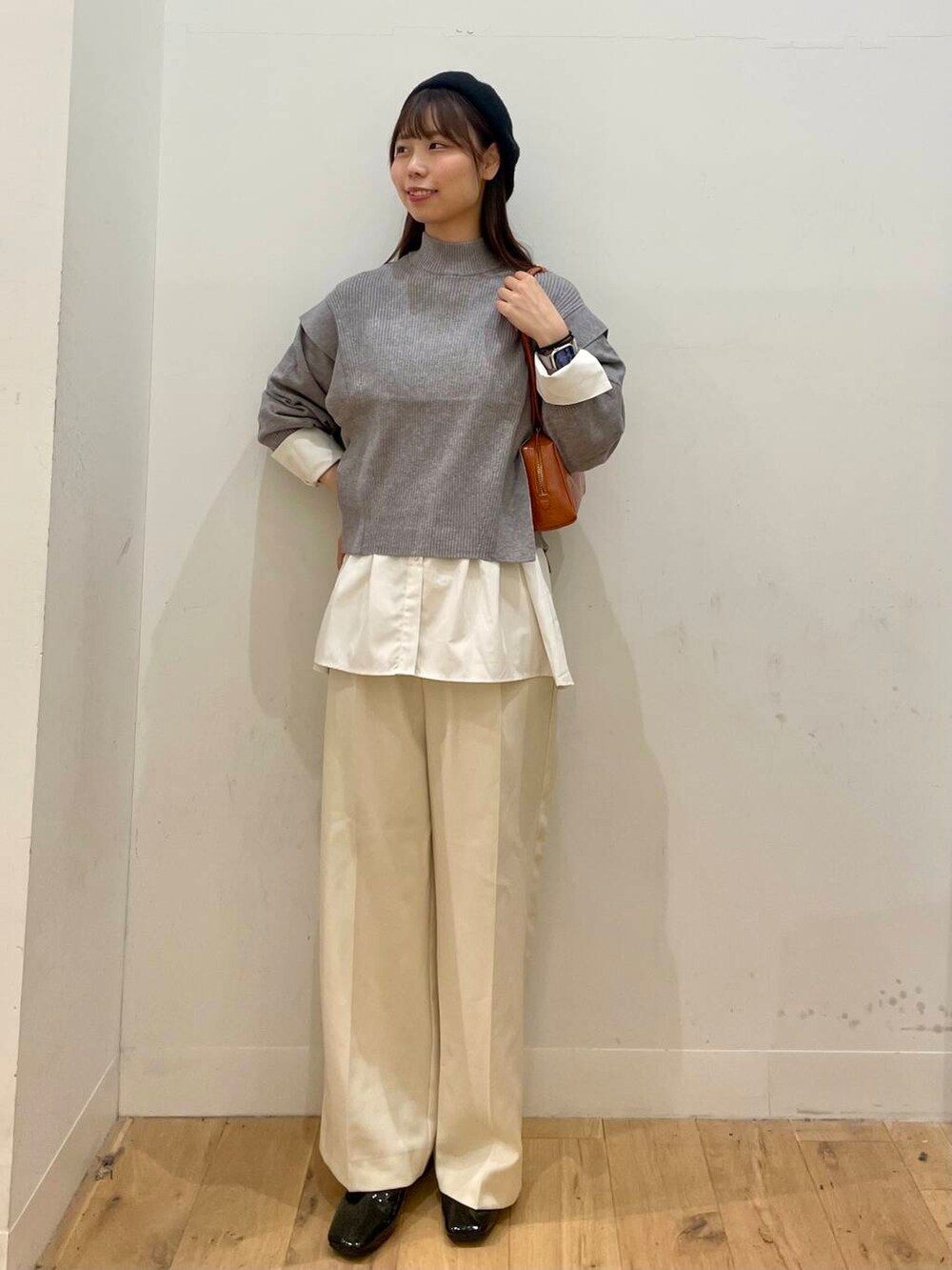 ホワイト系のシャツ/ブラウス、ブラック系のブーツ、オレンジ系のハンドバッグを着用したレディースの秋コーディネートの2枚目の写真