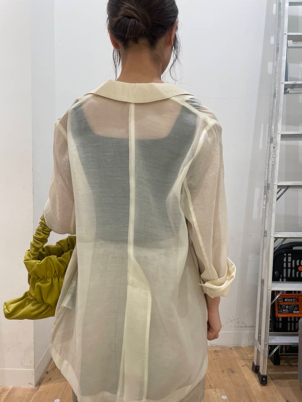 イエロー系のハンドバッグ、ブラック系のTシャツ/カットソー、ブラック系のサンダルを着用したレディースの秋コーディネートの5枚目の写真