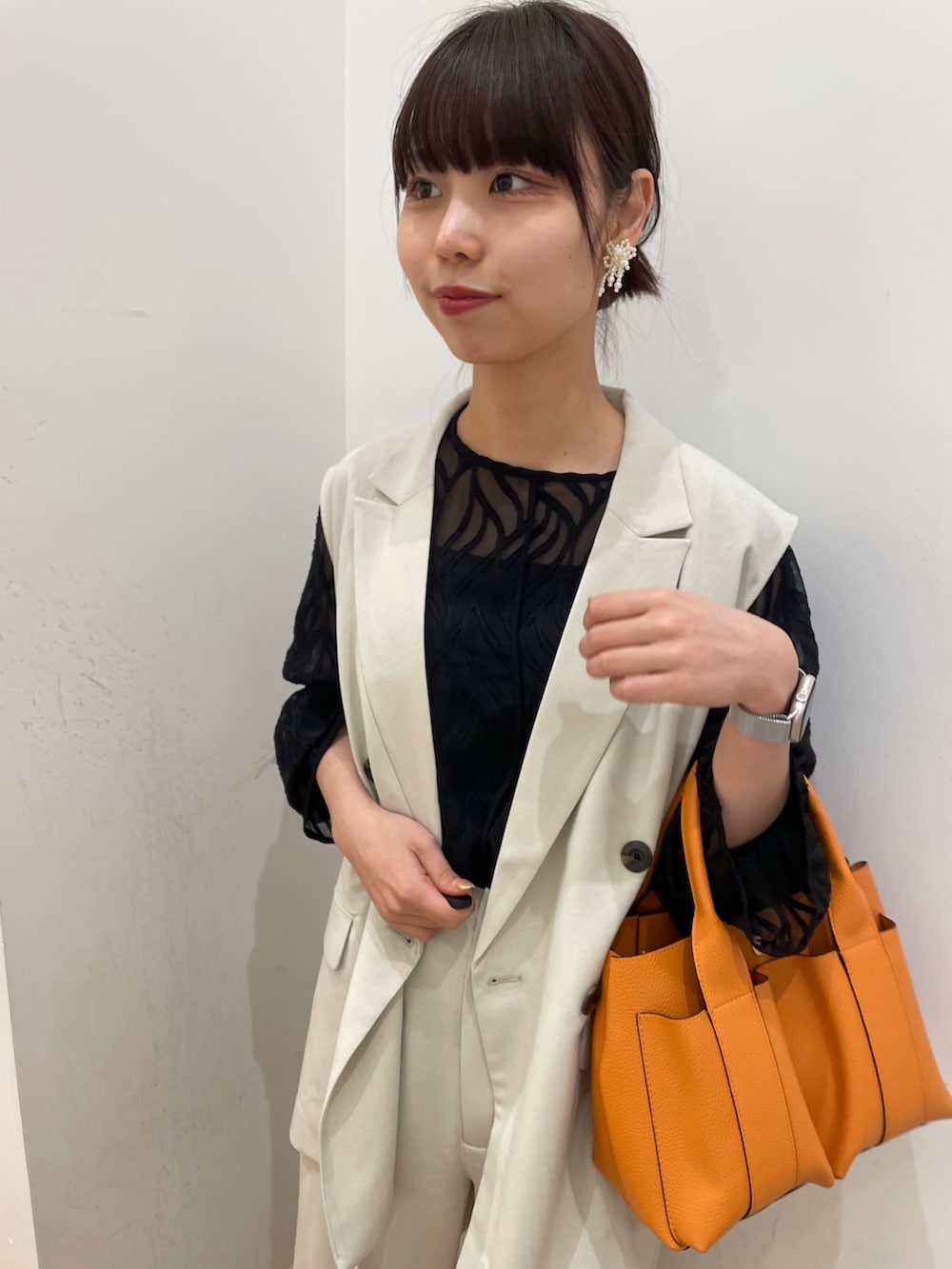 ベージュ系のその他アウター、ベージュ系のその他パンツ、オレンジ系のトートバッグを着用したレディースの春コーディネートの4枚目の写真