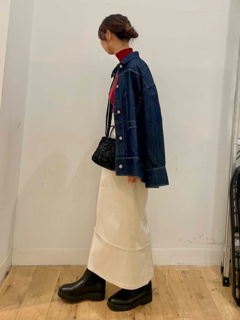 ブラック系のショルダーバッグ、レッド系のニット/セーター、ベージュ系のスカートを着用したレディースの秋コーディネートの2枚目の写真