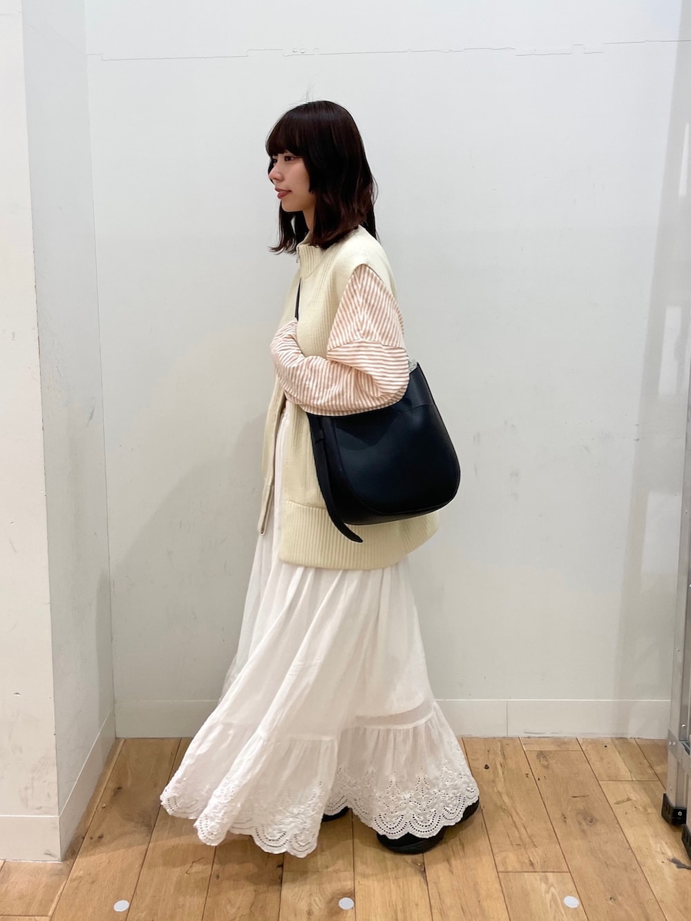 ホワイト系のスカート、ホワイト系のベスト、ピンク系のTシャツ/カットソーを着用したレディースの春コーディネートの2枚目の写真