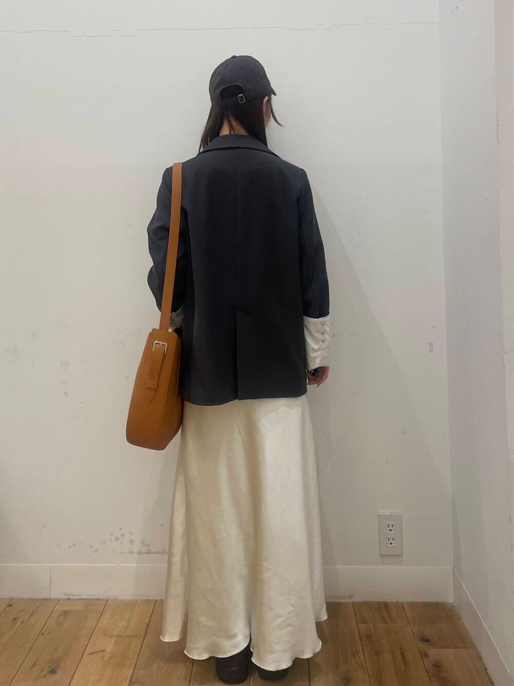 グレー系のテーラードジャケット、ブラック系のバレエシューズ、ブラウン系のショルダーバッグを着用したレディースの冬コーディネートの3枚目の写真