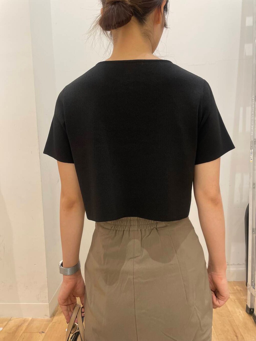 ホワイト系のハンドバッグ、ブラック系のドレスシューズ、ブラック系のニット/セーターを着用したレディースの夏コーディネートの5枚目の写真