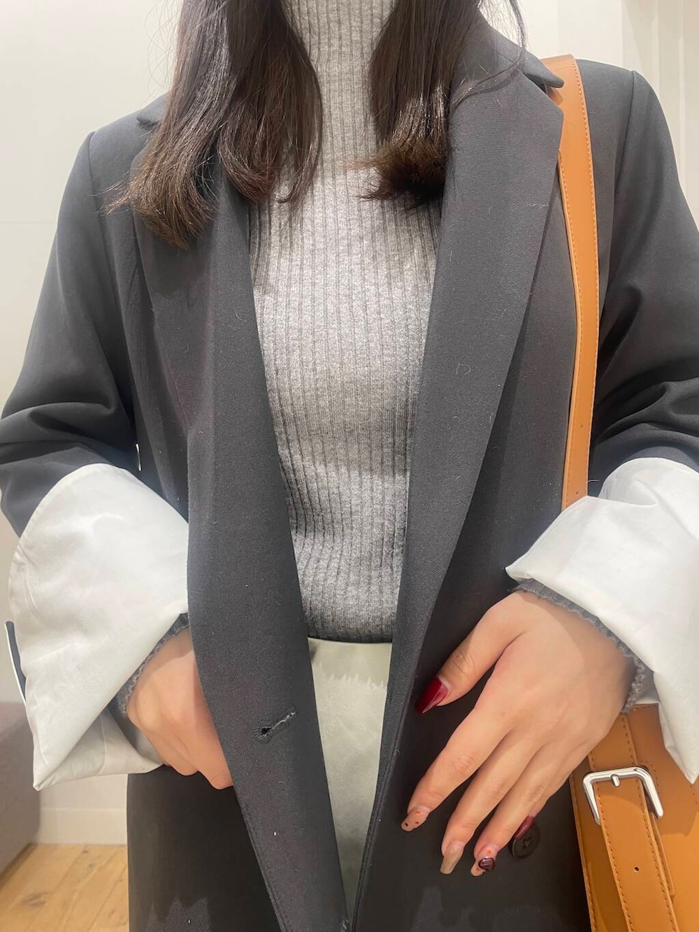 グレー系のテーラードジャケット、ブラック系のバレエシューズ、ブラウン系のショルダーバッグを着用したレディースの冬コーディネートの4枚目の写真